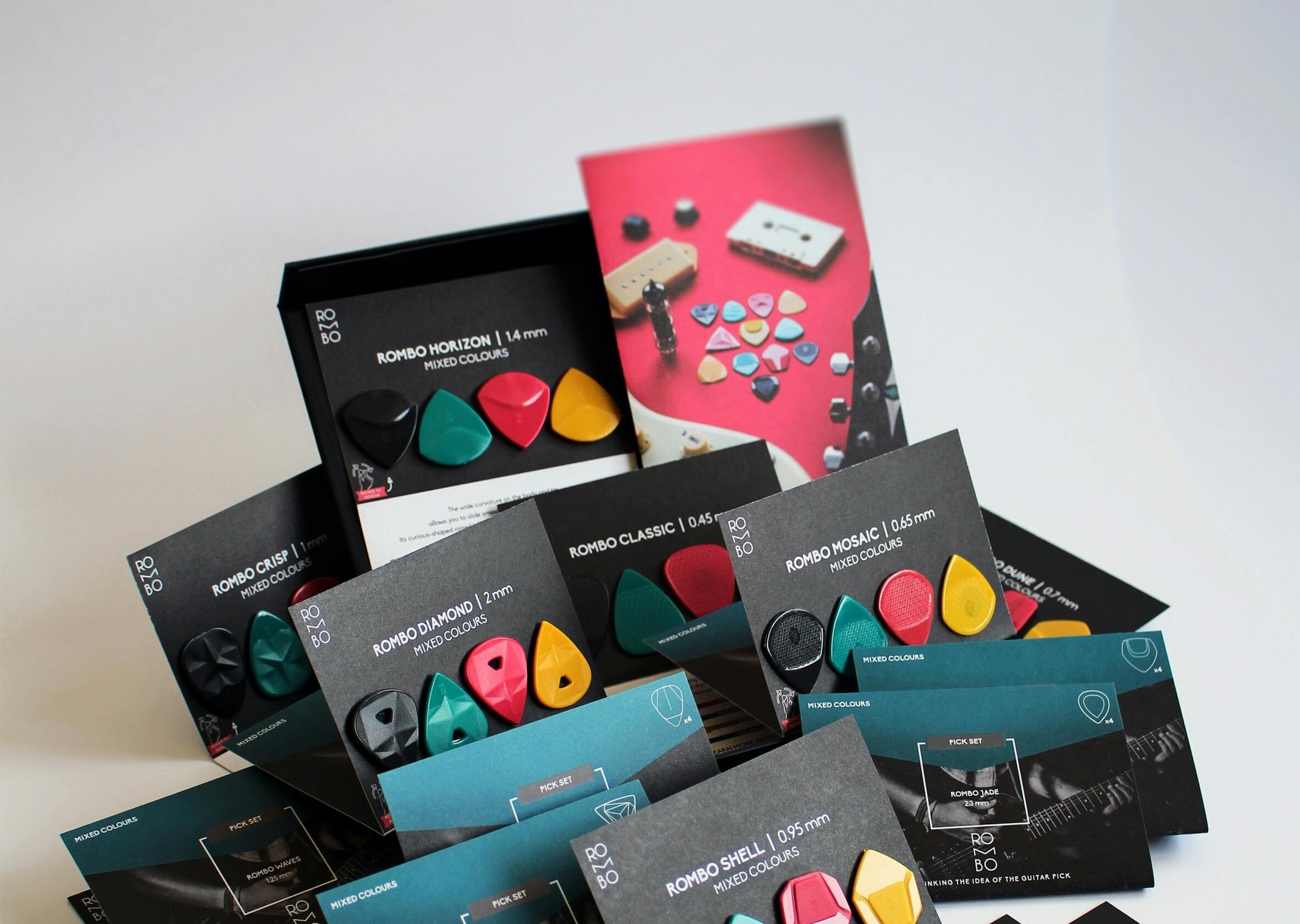 A variety of multi-colored guitar picks displayed in a square format with music equipment branding.